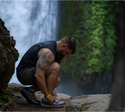 runner tying shoes in wilderness